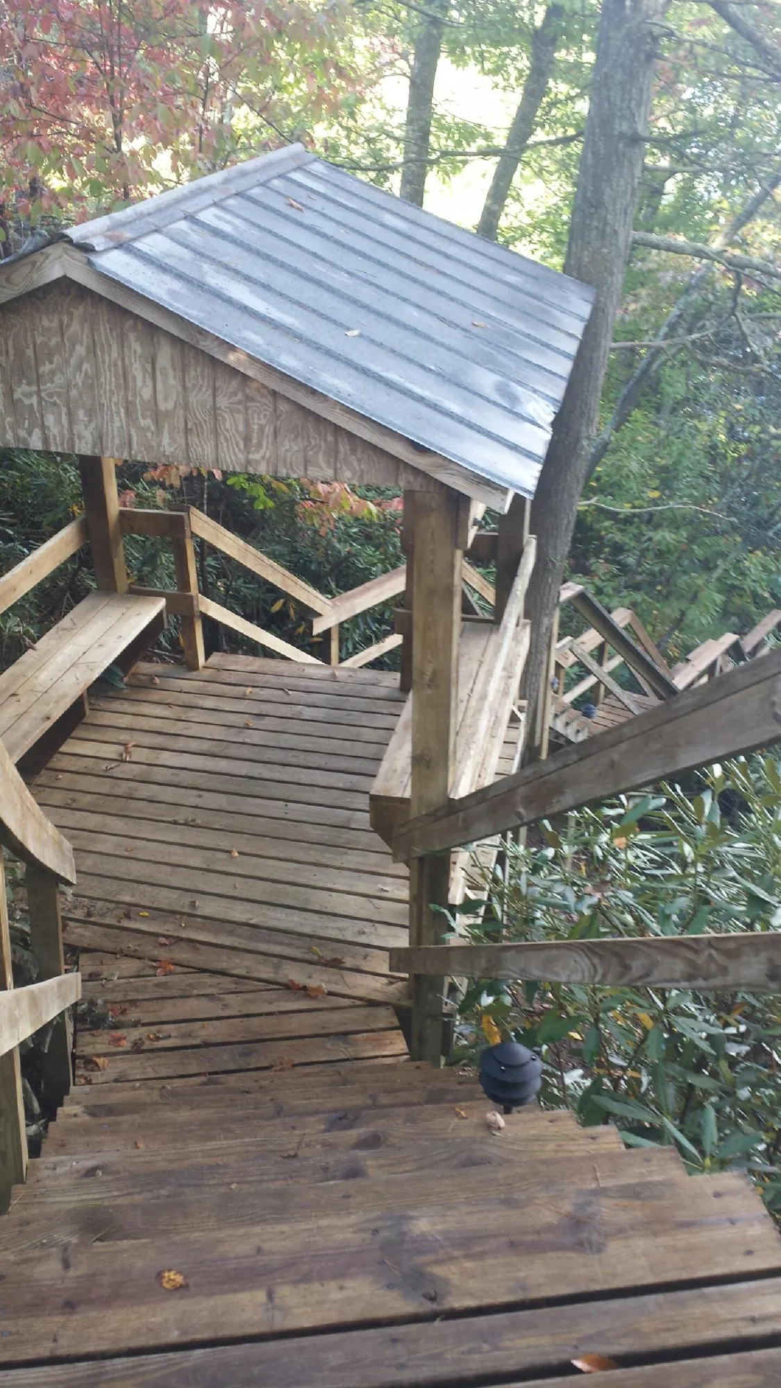 Metal roofed shelter over wooden steps on a wooded walkway — Skylight Repair & Installation work by our crew in Bristol