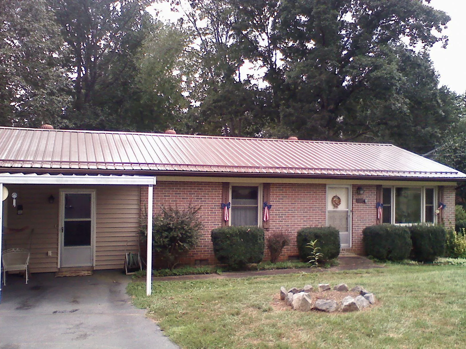 Bronze metal roof and carport on a brick ranch home — Roof Repair work by our crew in Bristol